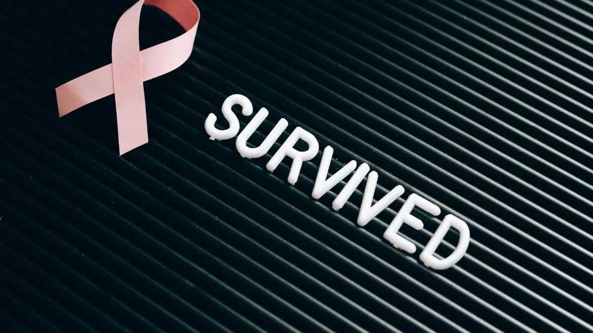 Pink ribbon and 'survived' text symbolize breast cancer awareness and survivorship.