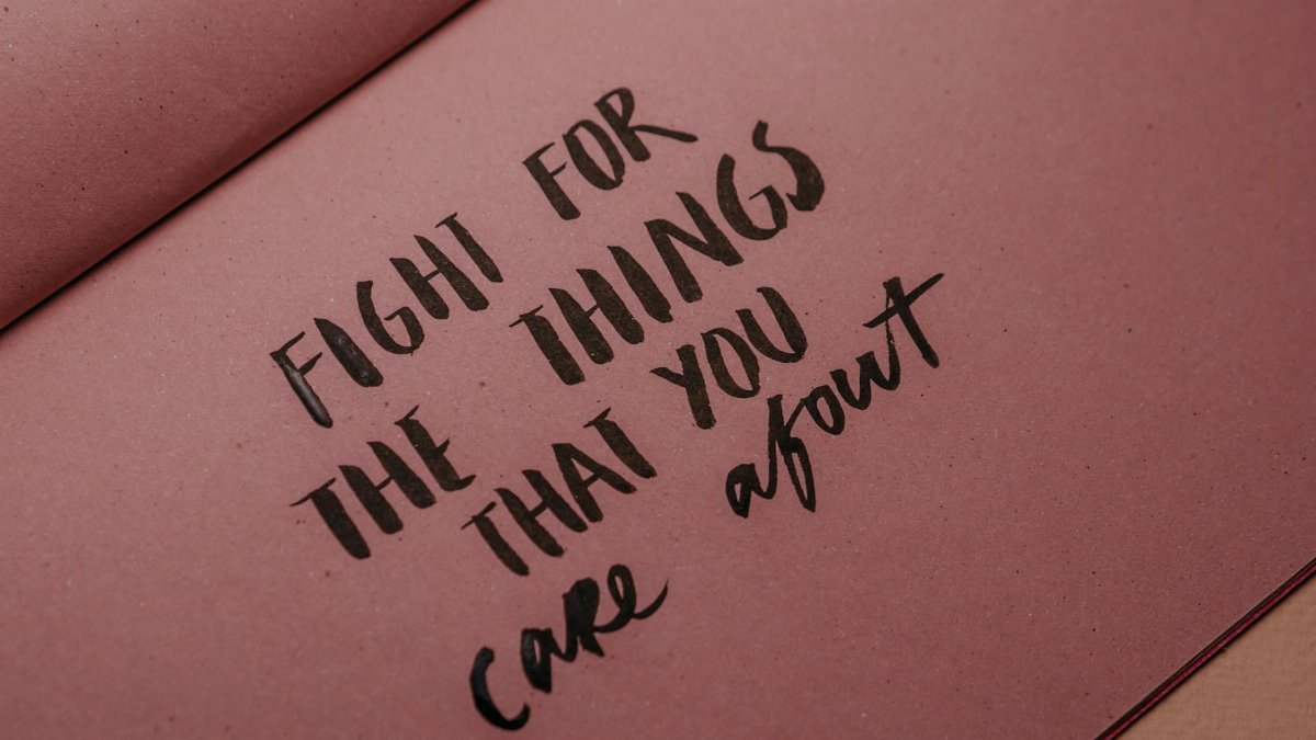 Hand-lettered inspirational quote on pink paper emphasizing motivation and self-care.