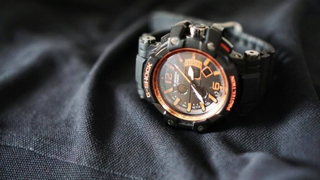 Close-up of a G-Shock sports watch with an analog display, resting on black fabric.