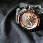 Close-up of a G-Shock sports watch with an analog display, resting on black fabric.