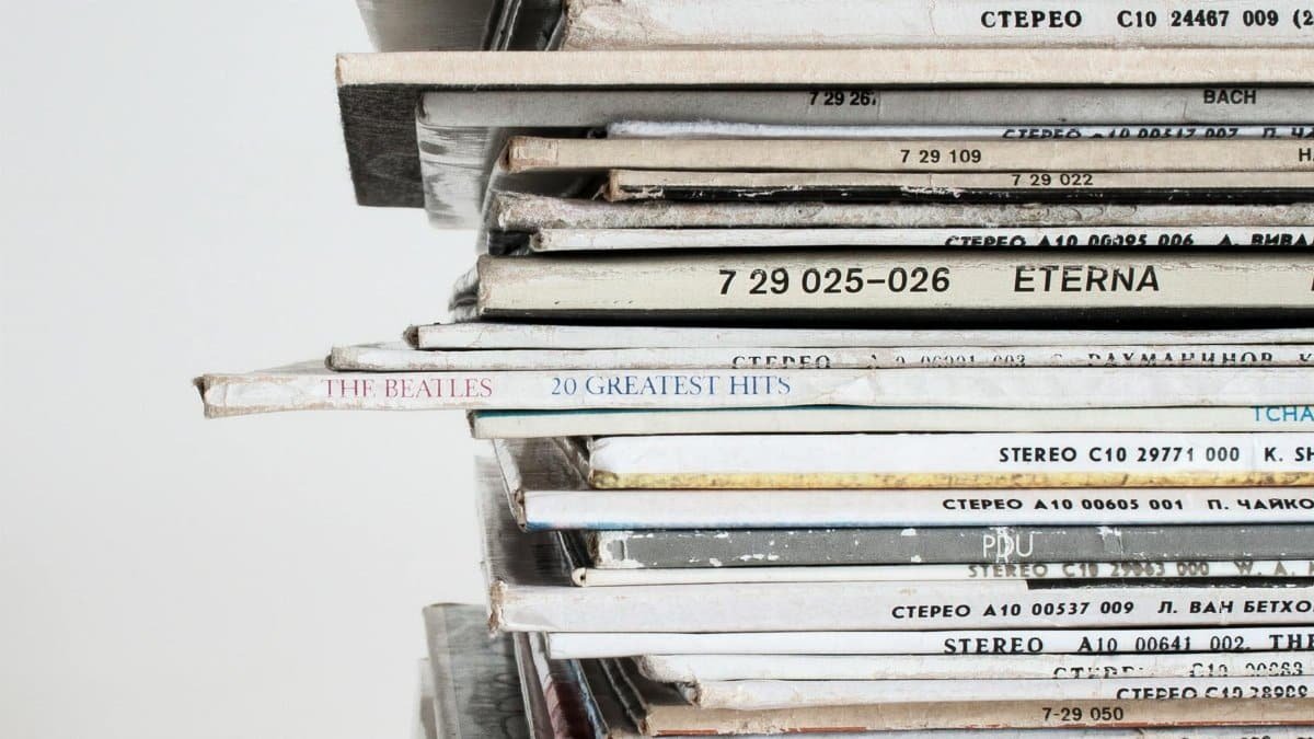 Close-up shot of a stacked pile of vintage vinyl record albums showcasing classic music covers.