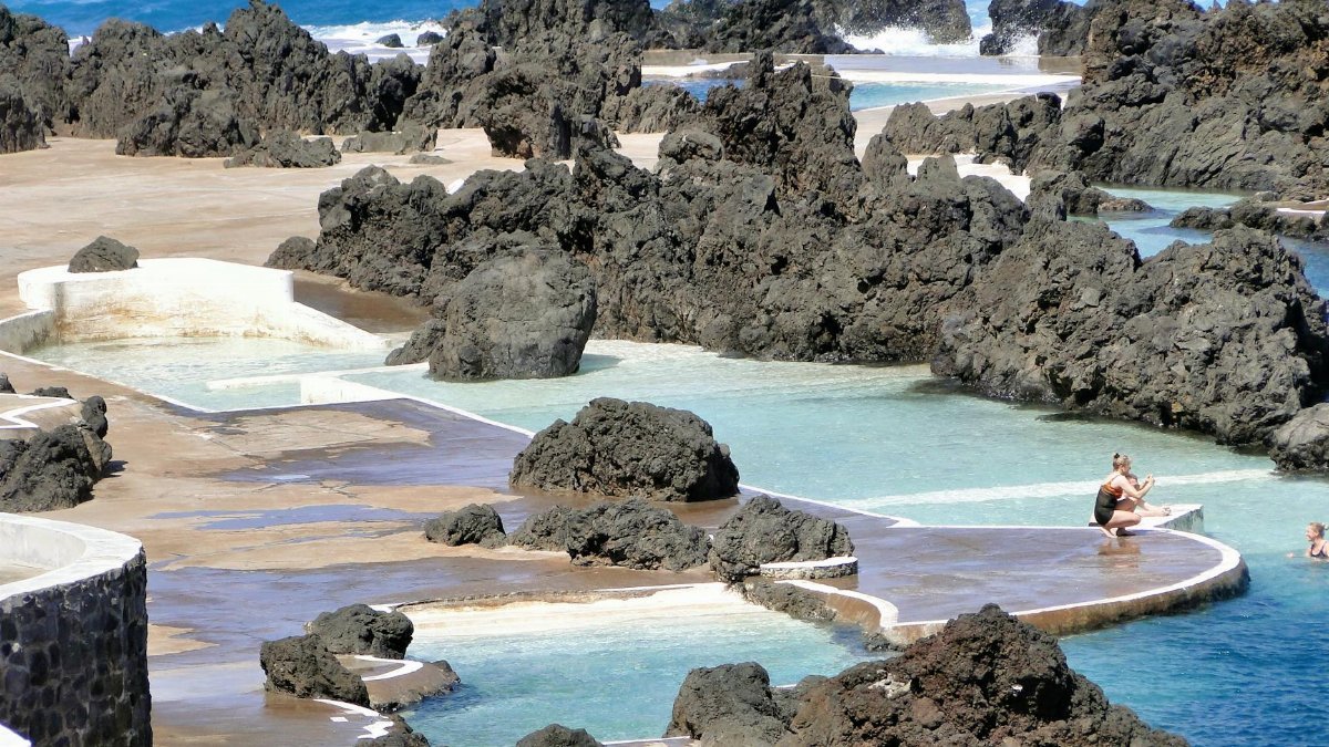 Scenic view of volcanic pools and rocky coastline in Porto Moniz, Madeira.