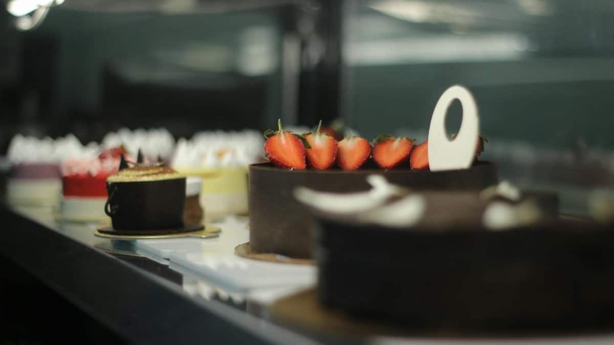 Assorted cakes displayed beautifully in a stylish café, offering a delightful and sweet indulgence.