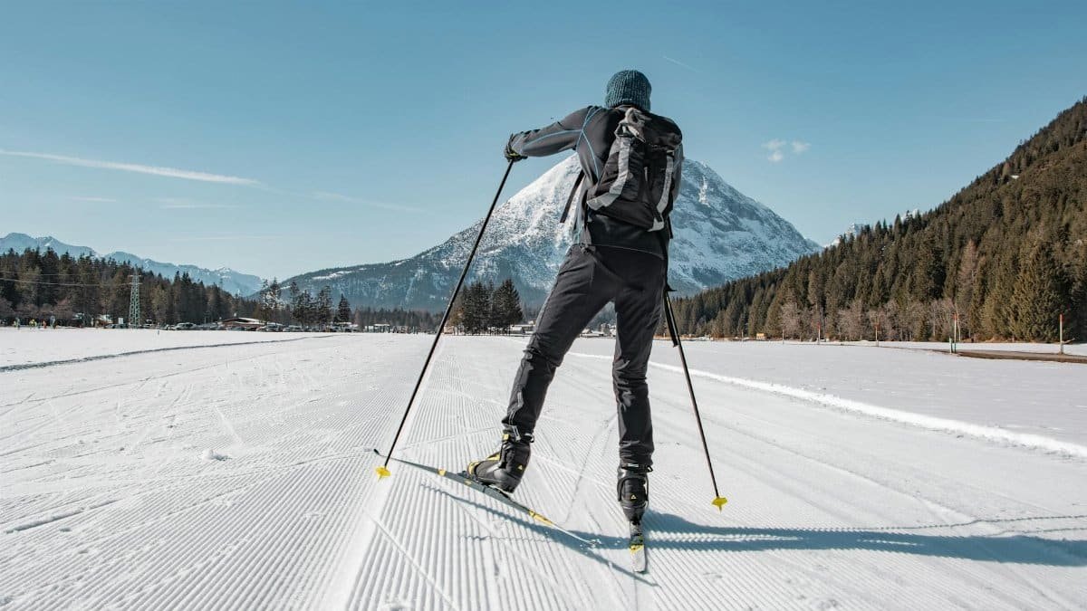 Skier enjoying cross-country skiing in beautiful Tirol, Austria, framed by snowy mountains.