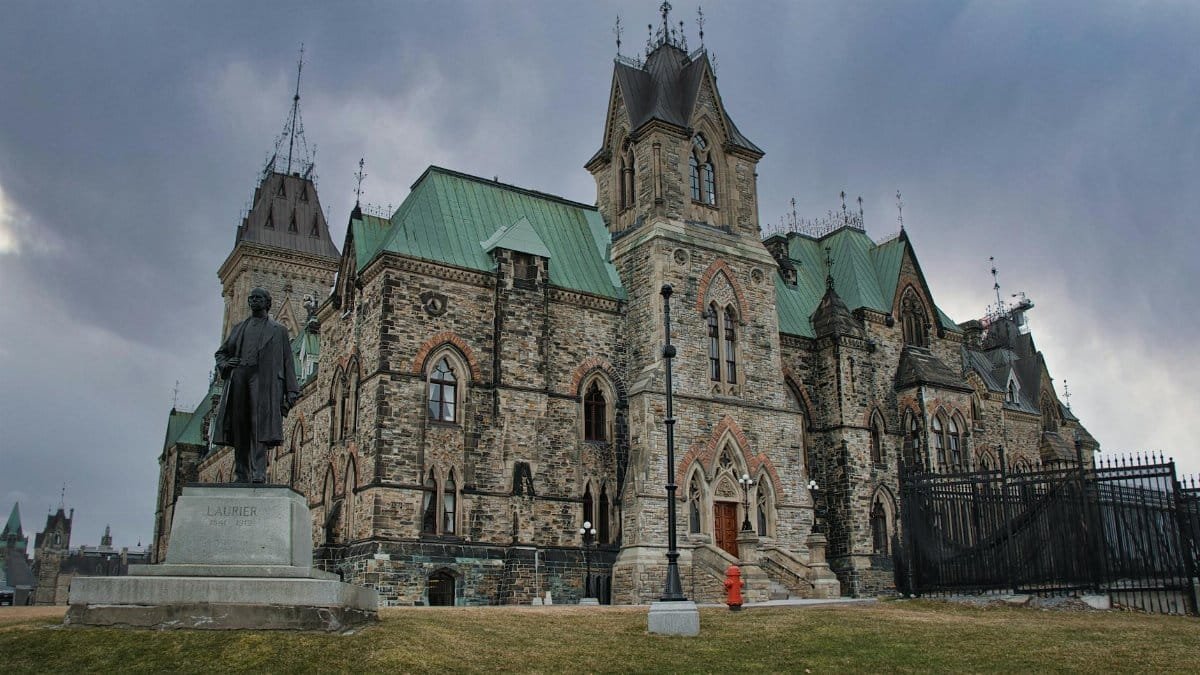 Historic Gothic revival building in Ottawa, Canada, with Laurier statue.