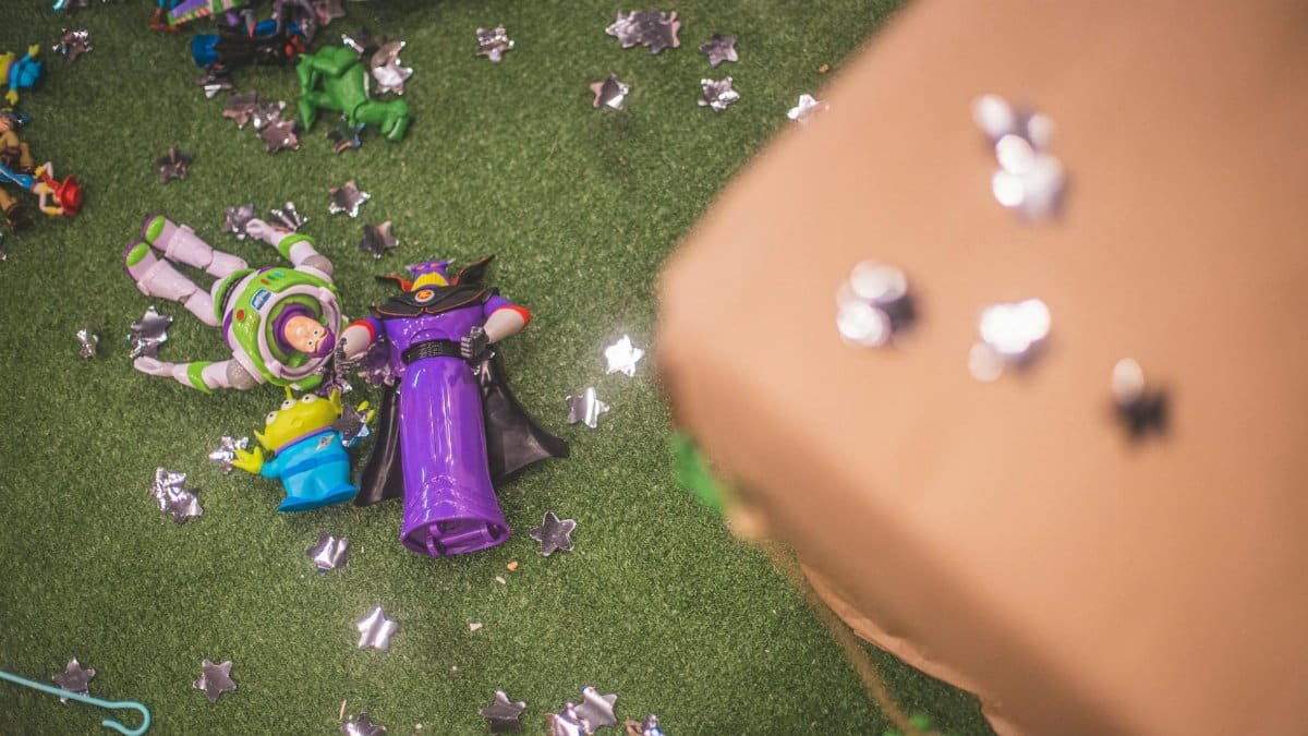Buzz Lightyear and Zurg toy figures on artificial grass surrounded by star-shaped decorations.