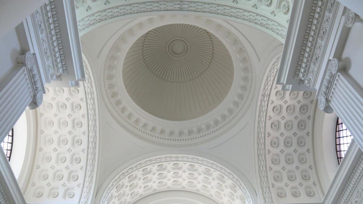 A stunning view of an ornate white dome ceiling with intricate architectural details.