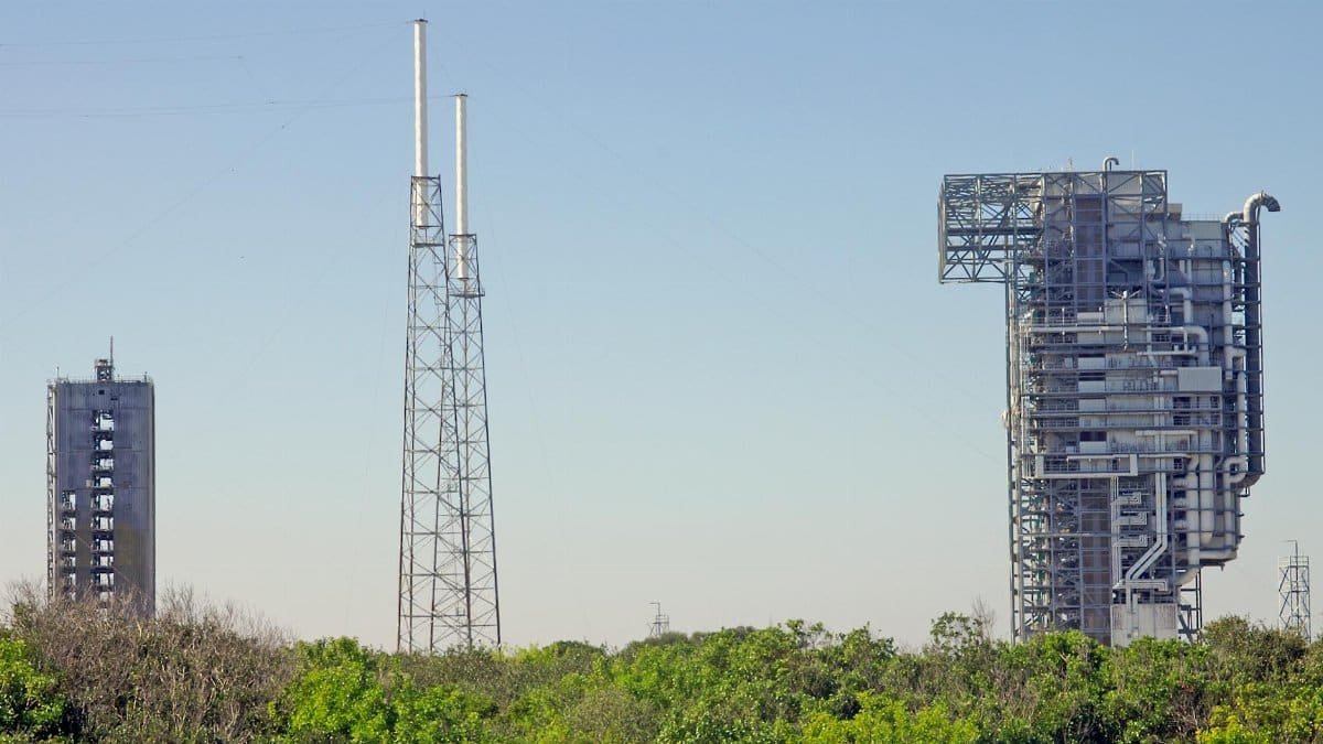 View of rocket launch gantry towers at Kennedy Space Center, Florida under clear sky.