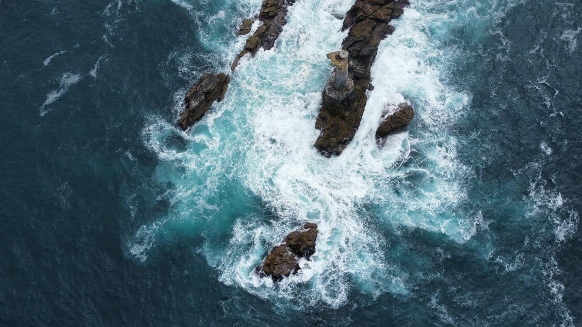 Drone captures powerful waves crashing against rocky formations at Ushant, Brittany, France.