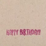 Minimalist 'Happy Birthday' message on a brown textured paper background.