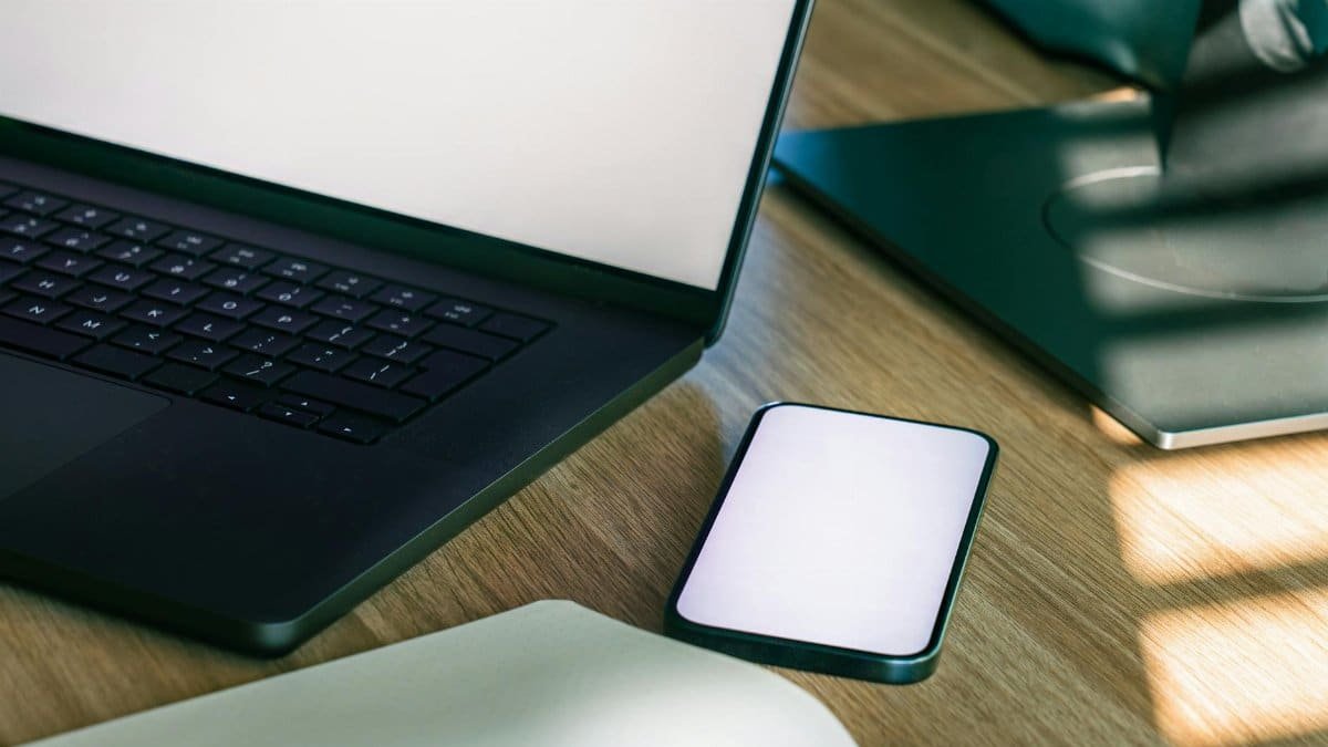 A sleek office desk setup featuring a laptop and smartphone, ideal for tech and business themes.