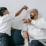 A father and son share a playful moment indoors, enjoying quality bonding time together.