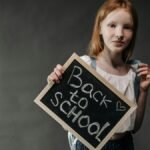 Young girl holding a blackboard with 'Back to School' message, perfect for educational themes.