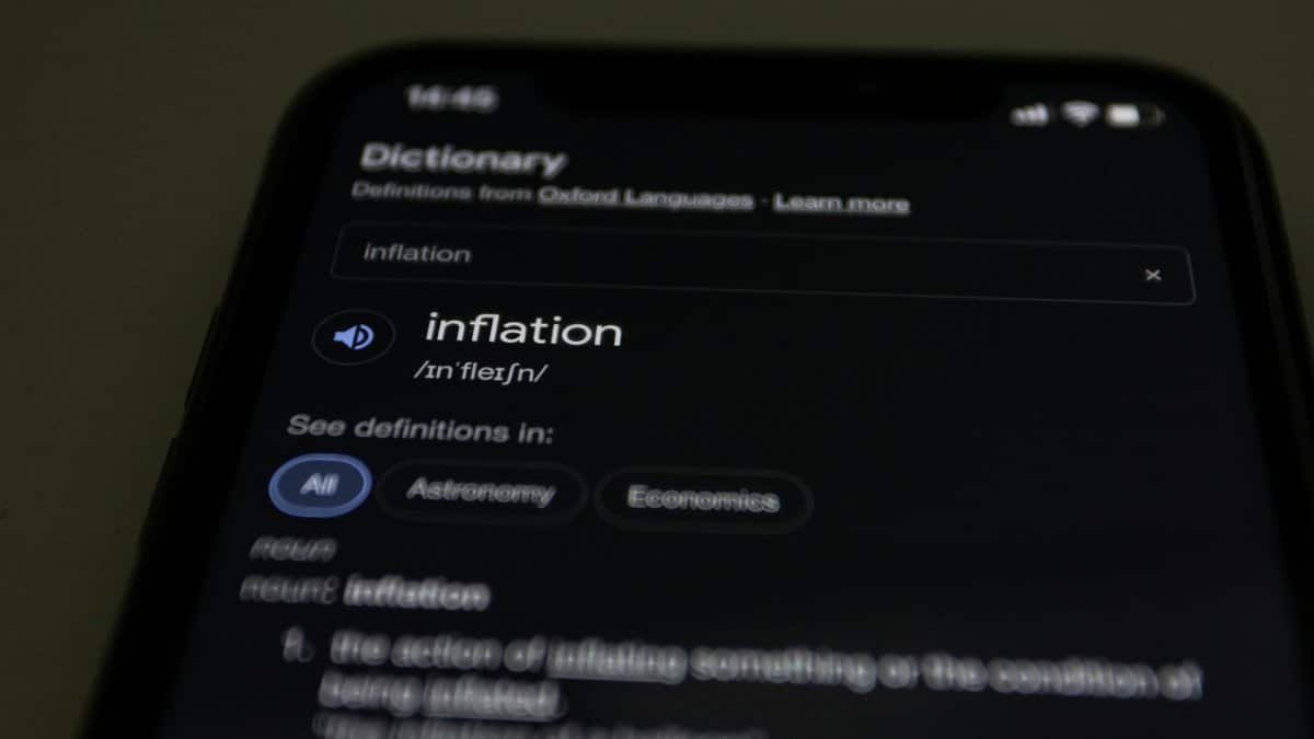 Close-up of a smartphone screen showing the word inflation defined in a dictionary app.