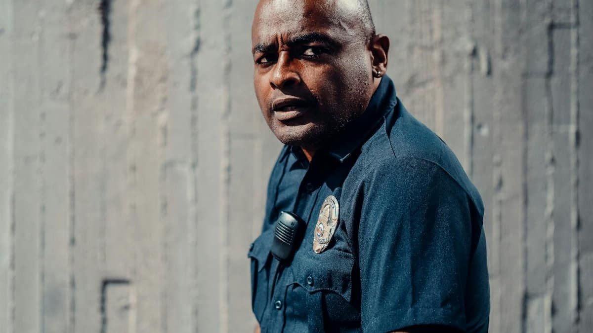 A dedicated police officer in uniform looking attentively outdoors, conveying dedication and professionalism.