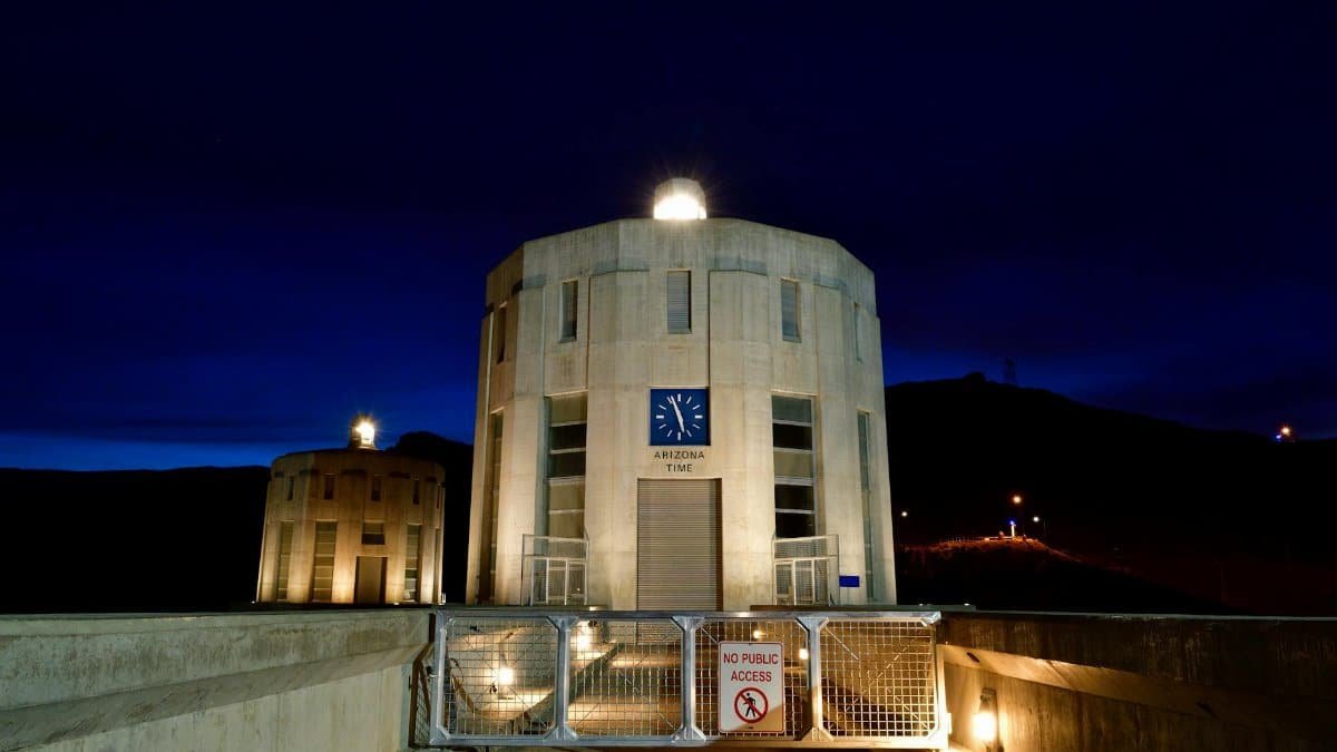 View of the Hoover Dam towers at twilight featuring Arizona time clock and gated entry.