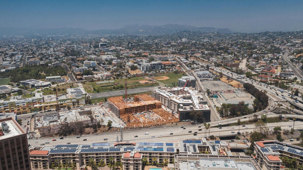 Aerial view showcasing the urban sprawl of Los Angeles with construction sites and highways visible.