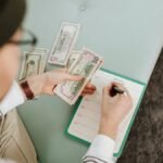 Individual budgeting with US dollars and a planner, focusing on financial planning.