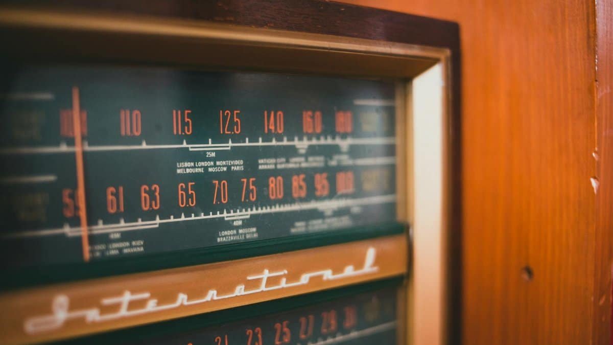 Detailed view of an antique radio dial showcasing stations and frequencies.