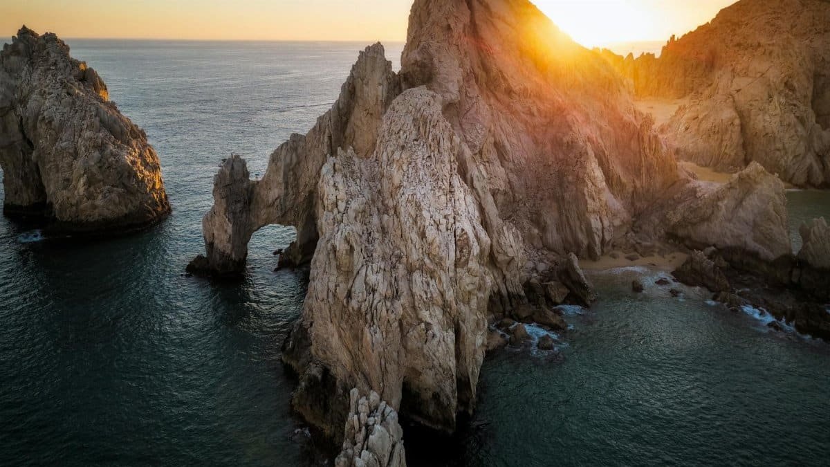Aerial view of the iconic Land's End rocks in Cabo San Lucas, captured at sunset.
