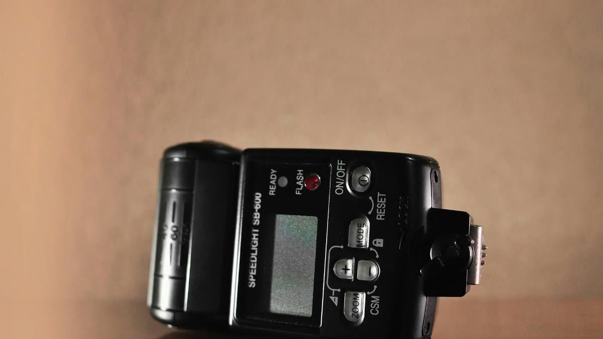 An SB-600 speedlight flash unit with display, buttons, and interface.