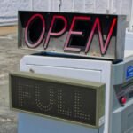 Photograph of a parking entrance showing 'Open' and 'Full' signs in daylight.