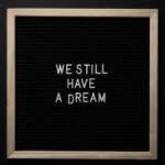 A black letterboard featuring the phrase 'We Still Have a Dream' symbolizing hope and unity.