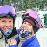 A happy couple in ski gear poses at Sundance Resort ski lift, Utah.