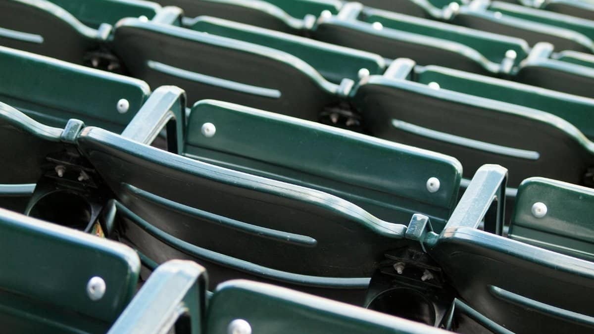 Close-up view of empty green stadium seats arranged in rows, conveying a sporting venue atmosphere.