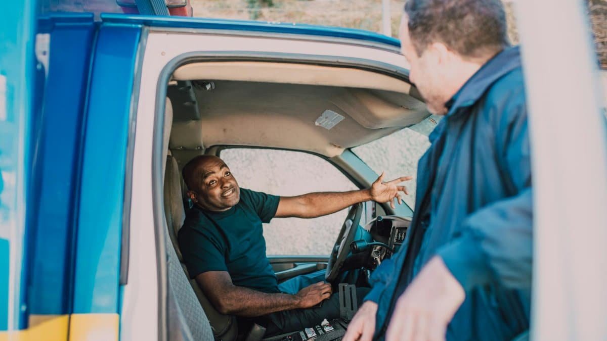 Emergency medical technicians engaged in conversation while preparing for duty in an ambulance.