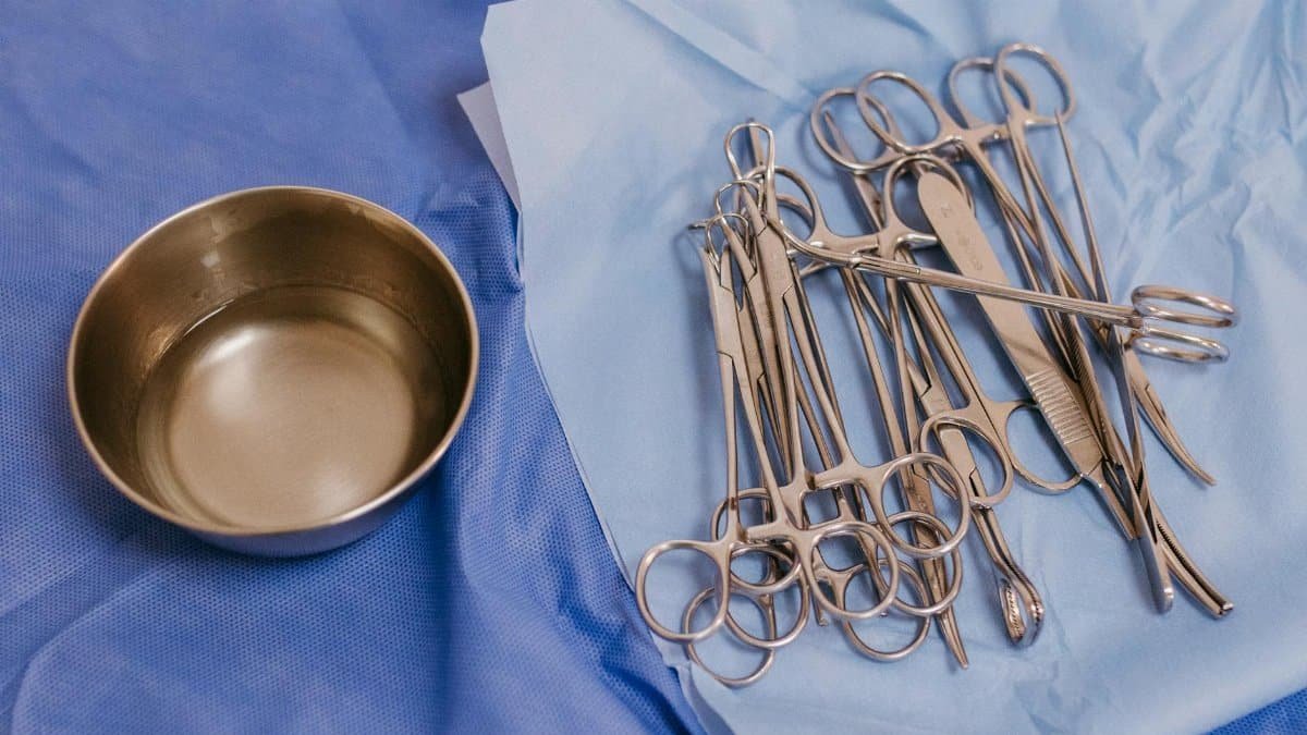 Sterile surgical instruments laid out on blue surgical drapes ready for medical procedures in a clinical setting.