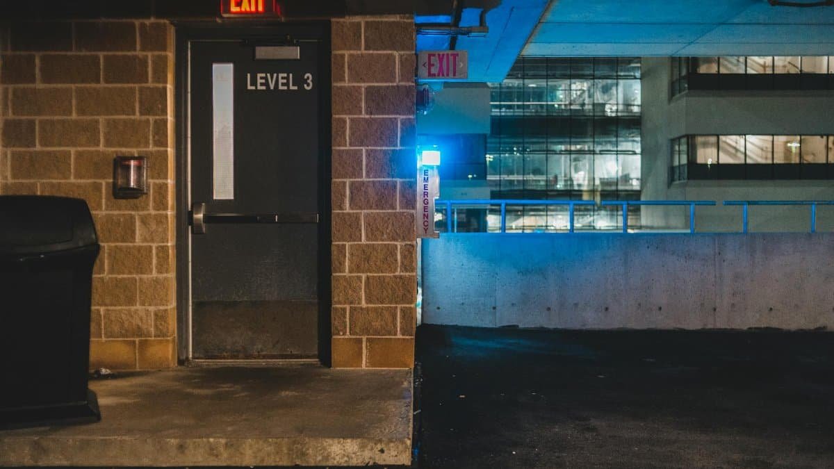 Exterior of concrete shabby building with luminous lights and balcony in late dusky evening