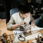 A watchmaker carefully repairs a clock on a cluttered workbench surrounded by tools.