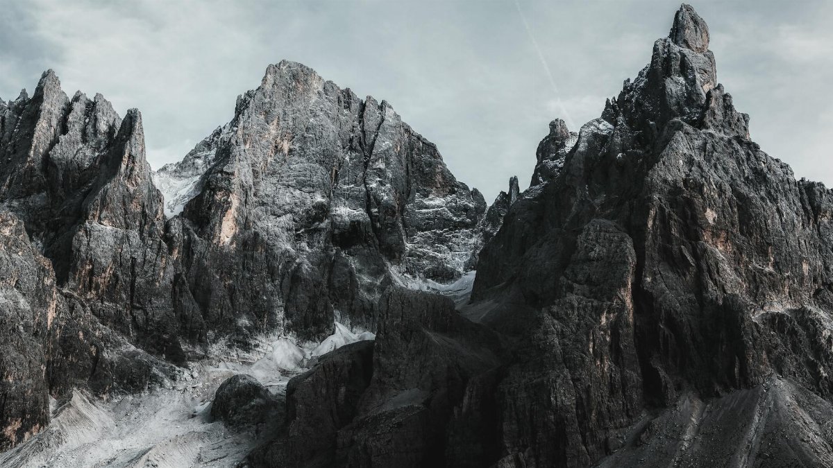 Dramatic rock formations of a rugged mountain range under a moody sky, exemplifying natural beauty.