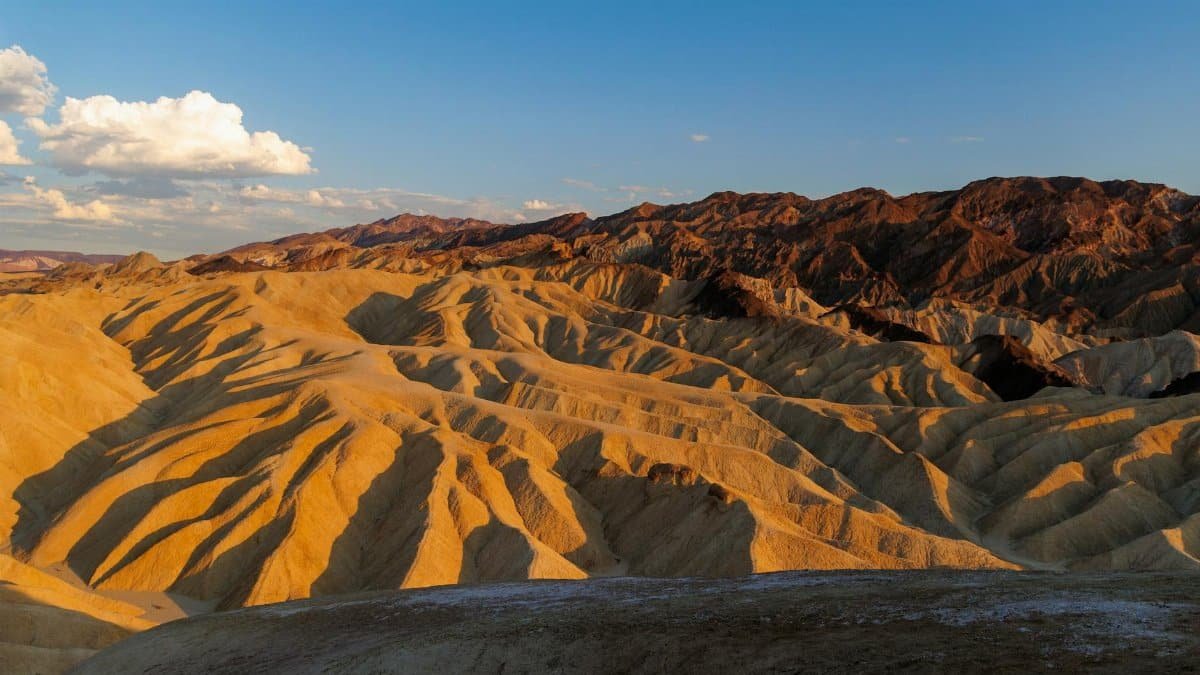 Golden hues of Zabriskie Point at sunset taken in Death Valley National Park, showcasing desert beauty.