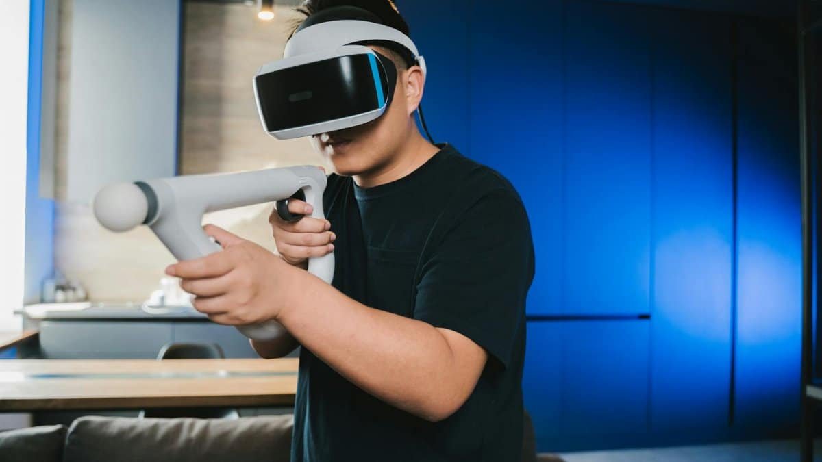 A man using a virtual reality headset and controller for an immersive gaming experience at home.