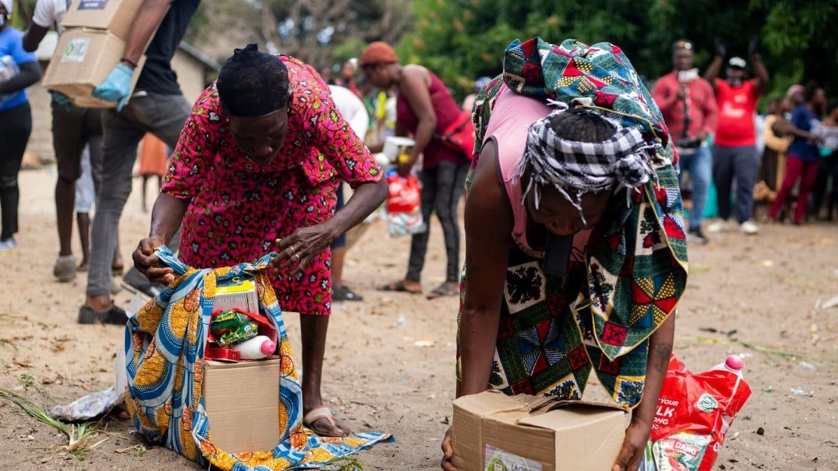 People collecting relief supplies in a community outdoor setting.