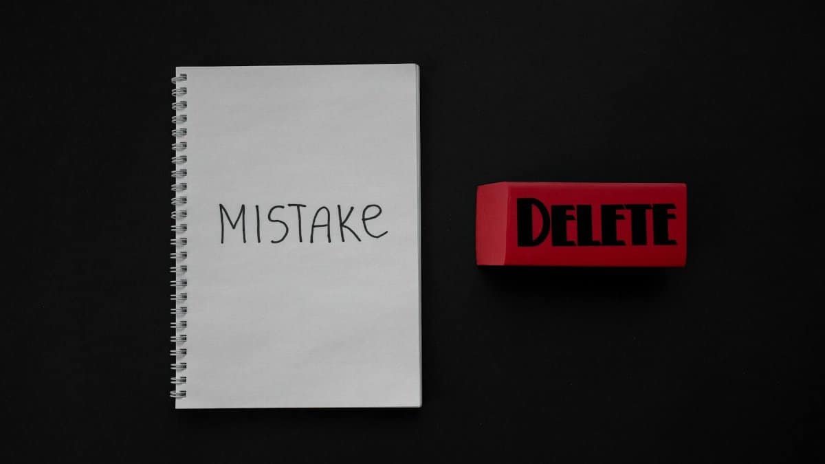 Notebook labeled 'Mistake' next to a red delete eraser on a dark background.