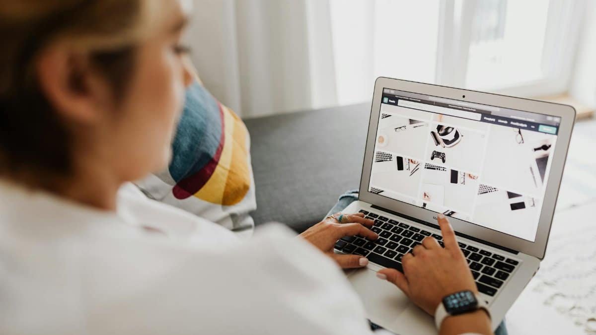 Person using laptop in a cozy home setting, focusing on digital content browsing.