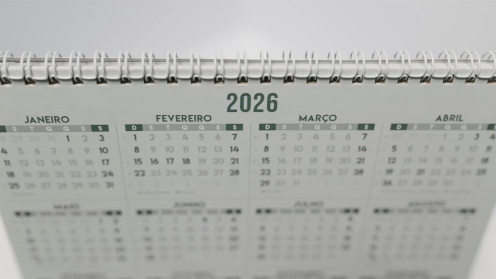 Close-up of a 2026 spiral-bound desk calendar with months in Portuguese.