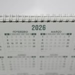 Close-up of a 2026 spiral-bound desk calendar with months in Portuguese.