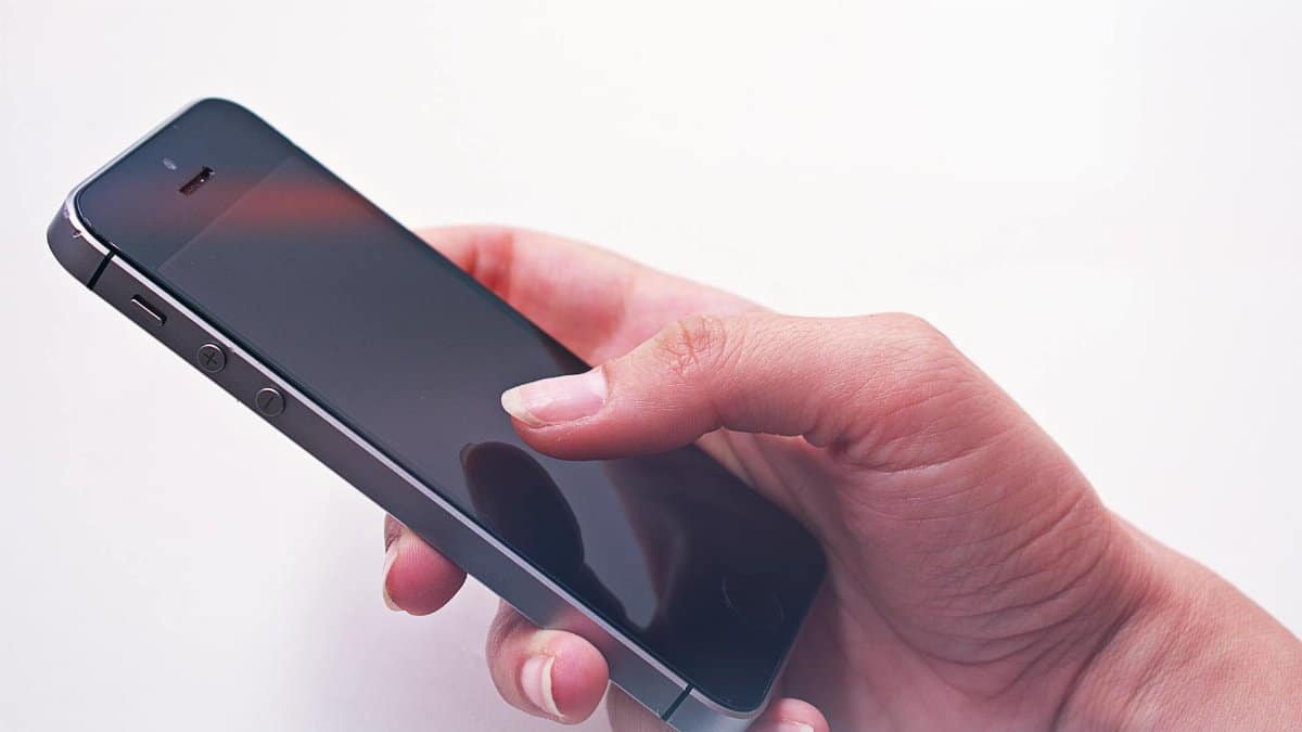 A person's hand holding a smartphone, showcasing modern technology and connectivity.