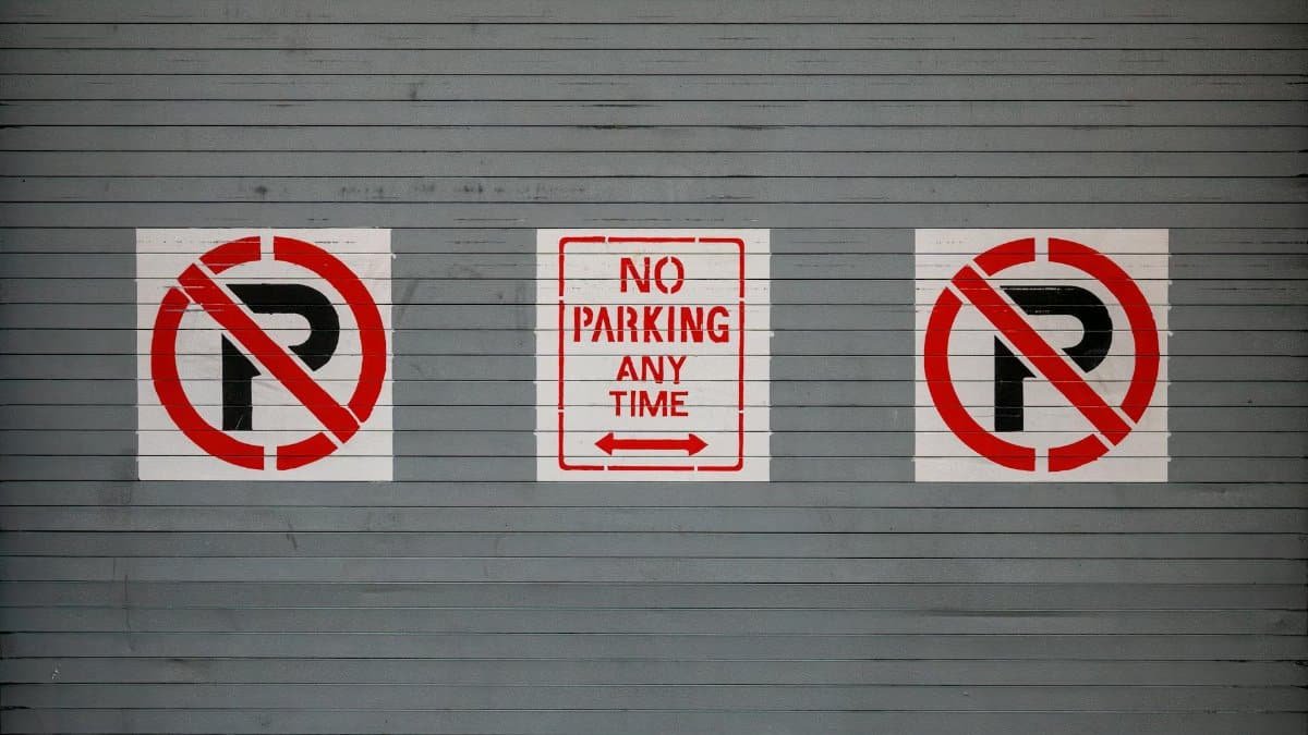 Red no parking signs on a gray wall in San Francisco, California.
