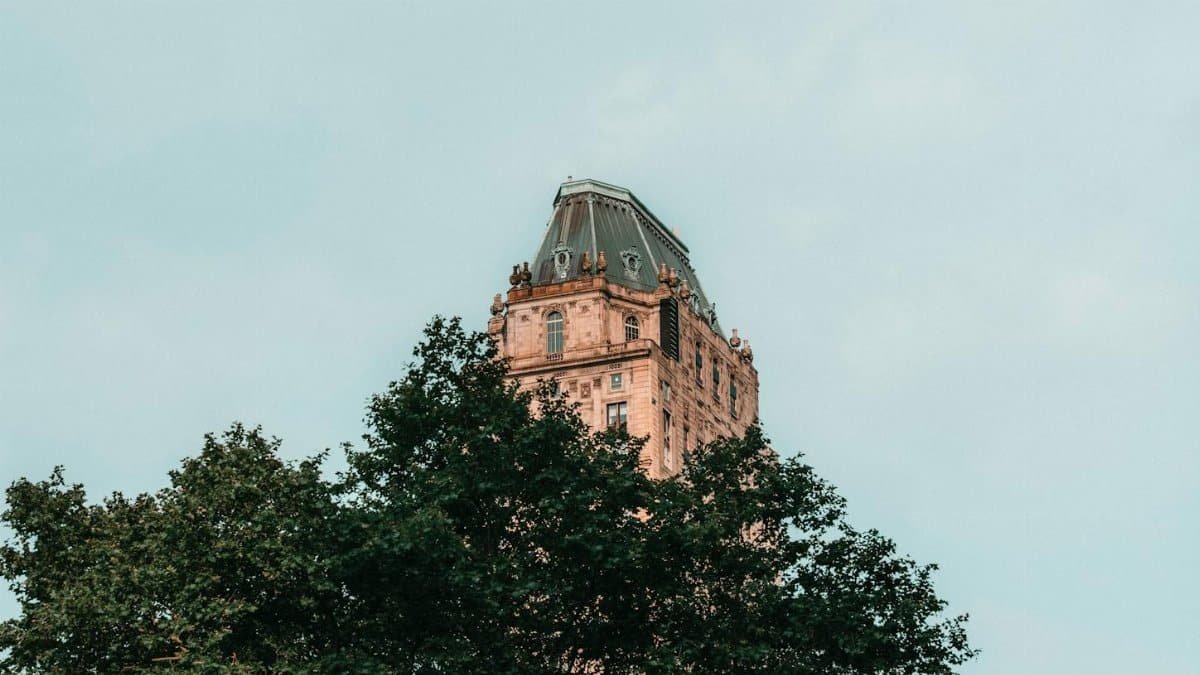 Close-up of a historic building top view partially hidden by trees in New York.