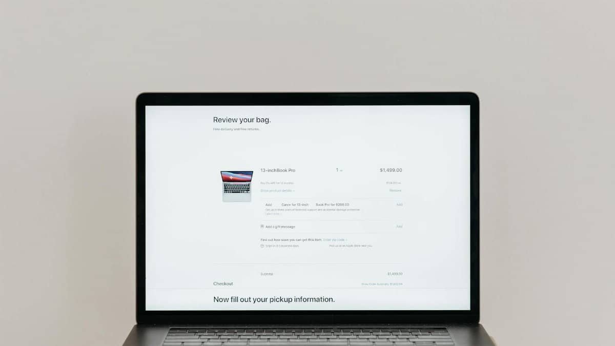 Minimalist laptop showing an online checkout screen on a white background, ideal for tech context.
