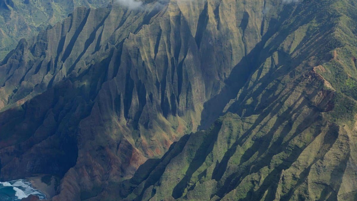 Stunning aerial shot of the rugged Na Pali coast in Kauai featuring dramatic cliffs.