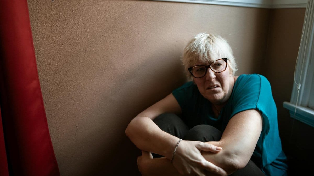 Portrait of an adult woman in thought, representing survival and strength indoors.