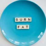A conceptual image featuring the words 'Burn Fat' on a blue plate, symbolizing weight loss.