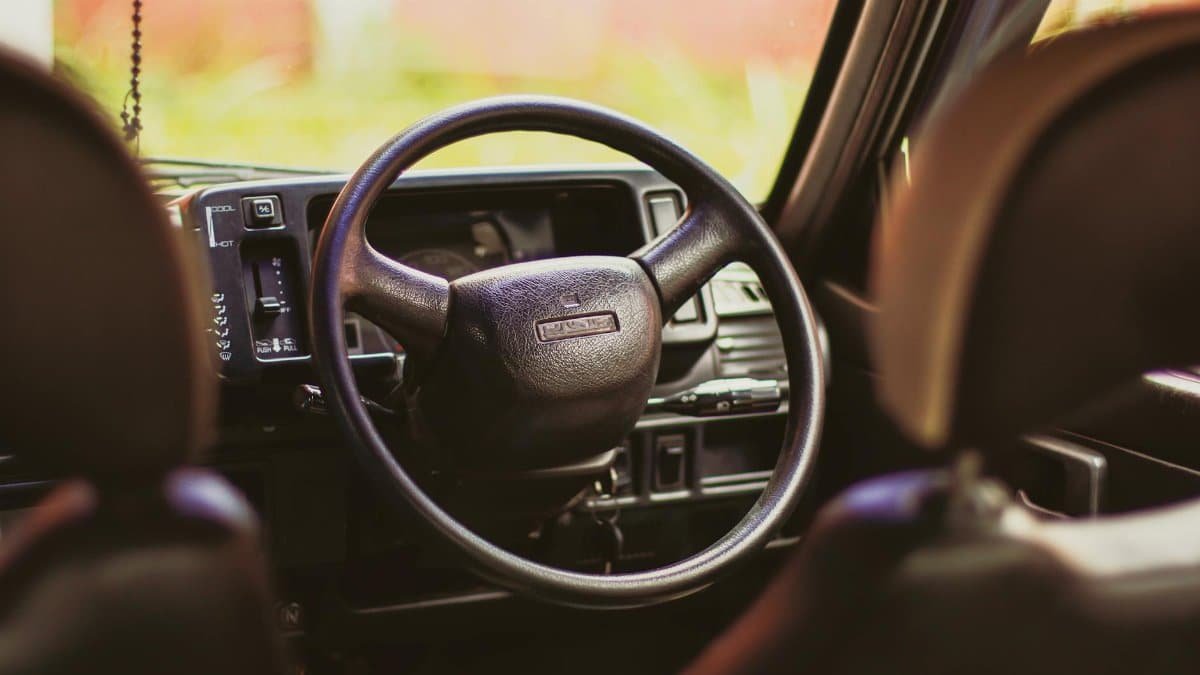 Close-up of the steering wheel in a classic Maruti 800, highlighting vintage automotive design details.