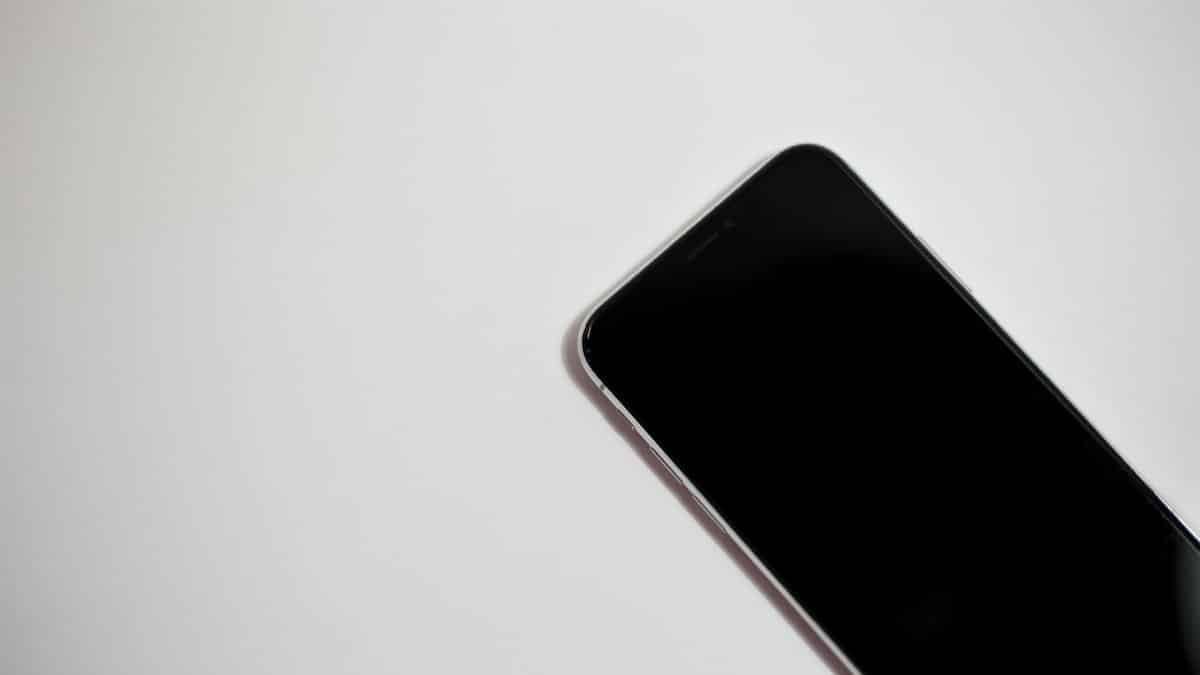 Close-up of a smartphone with black screen on a white background, perfect for technology themes.